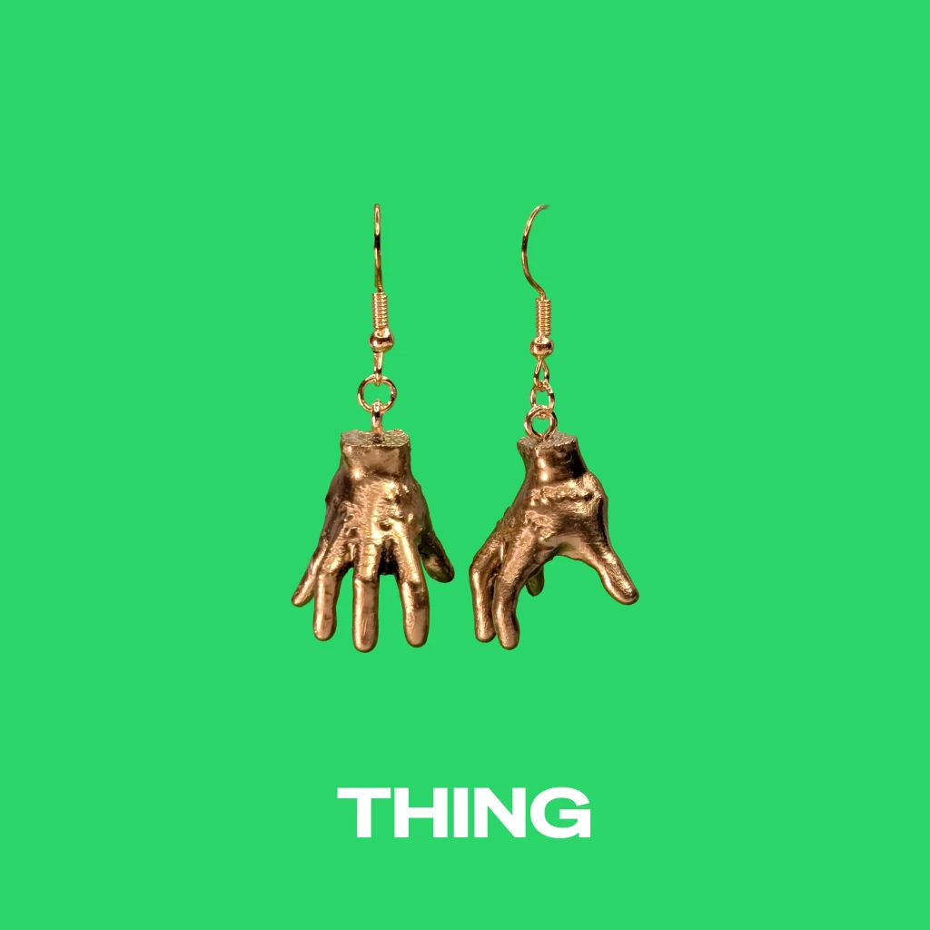 Thing gold earrings on a green background