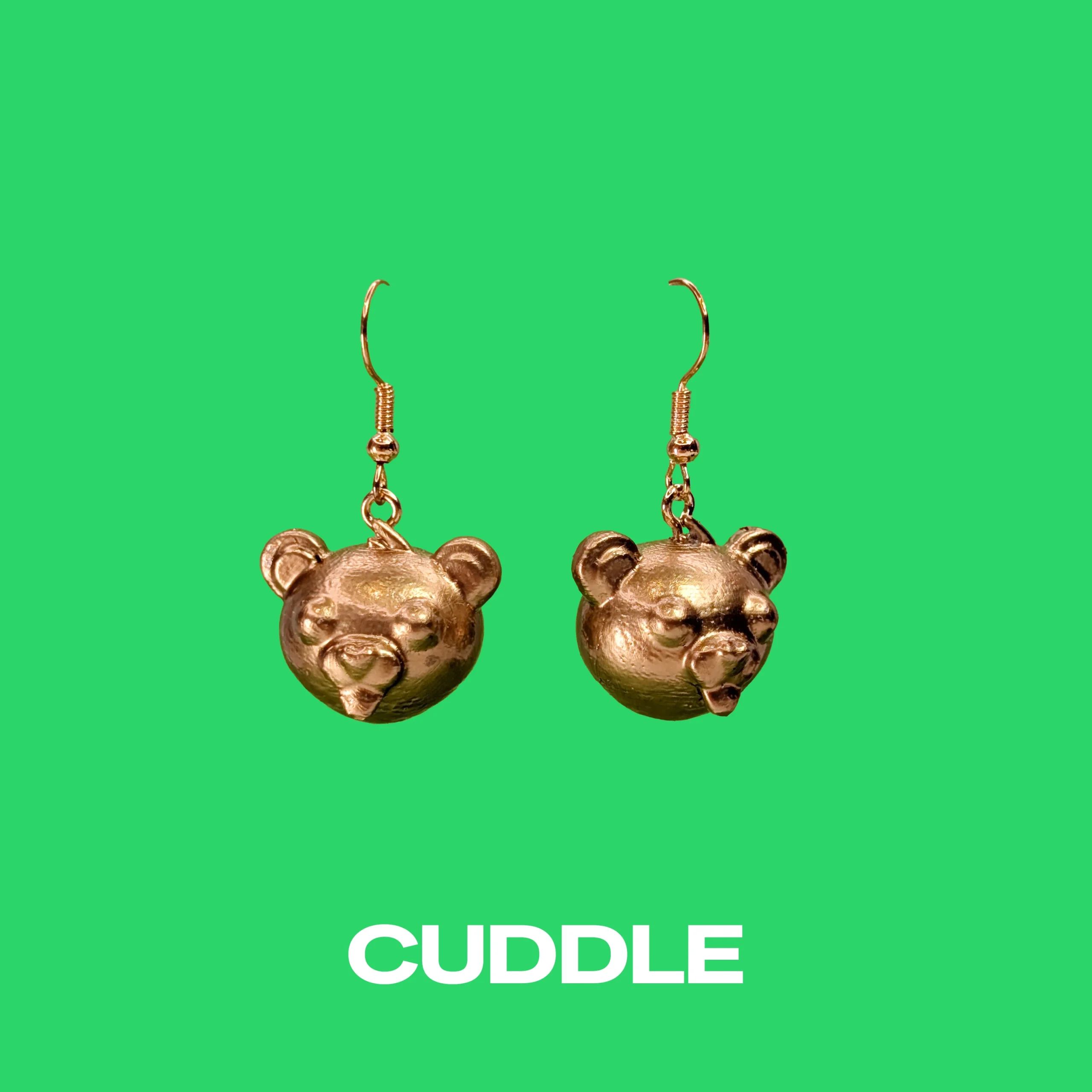 Cuddle gold earrings on a green background